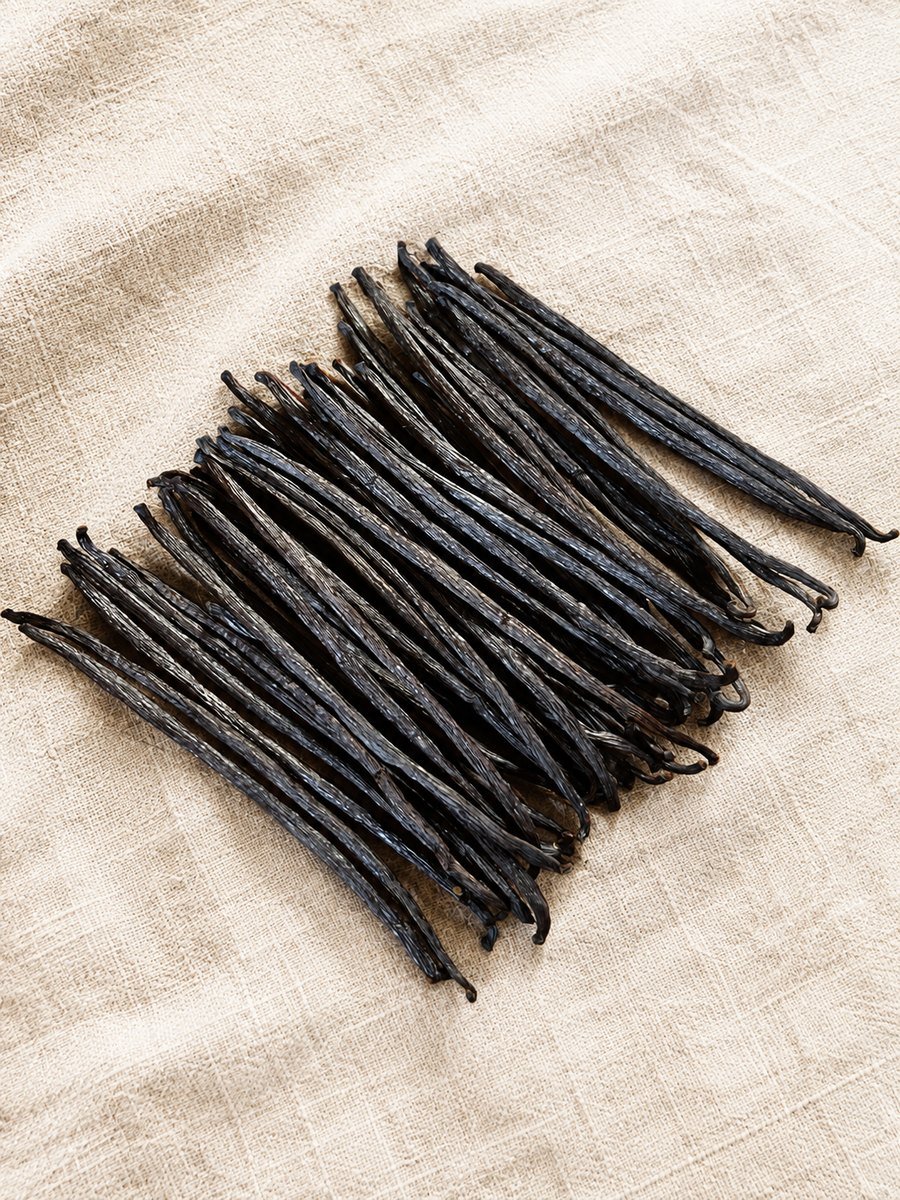 Indonesian cured vanilla beans on a bright natural linen background